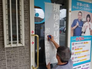 カッティングシートを貼る作業 | 堺ゆらり治療室の看板リニューアル